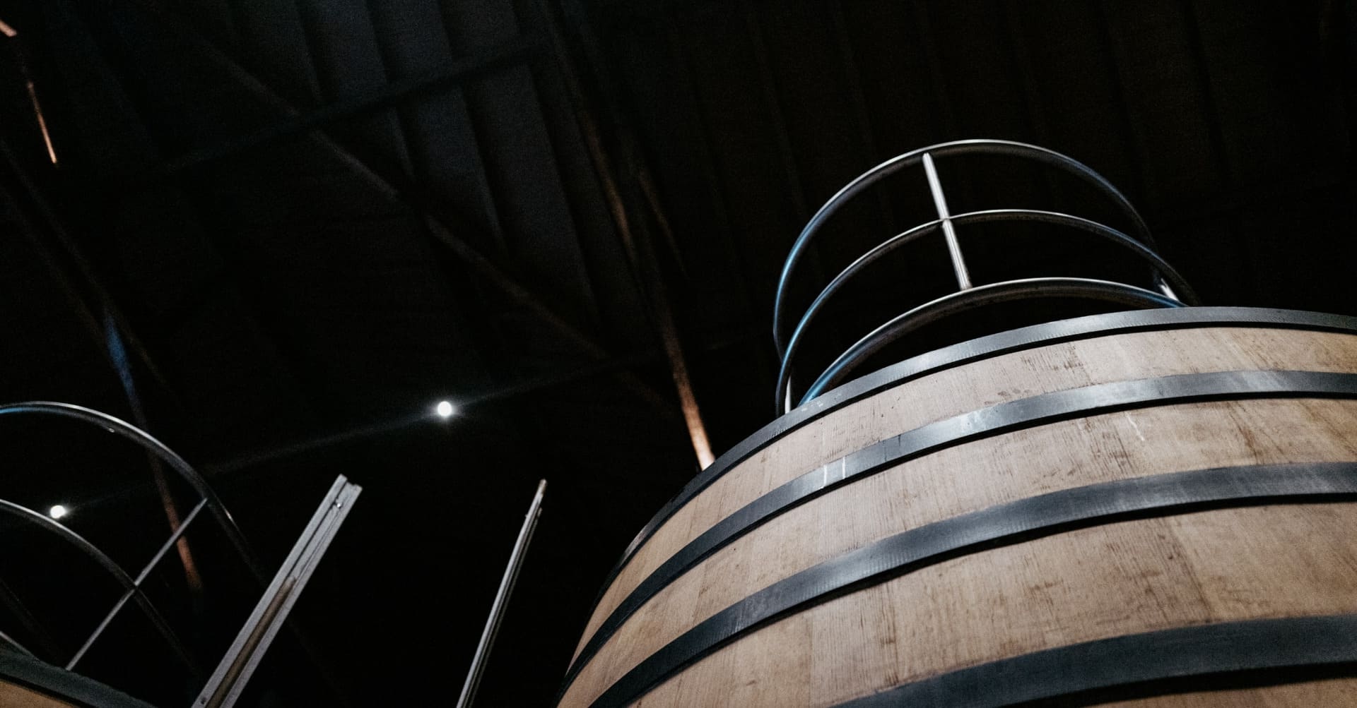 View towards top of wooden wine vat, showing ceiling of winery at Brane-Cantenac.